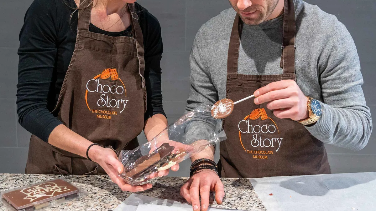Chocolatier showing a piping bag in a workshop at the Brussels chocolate museum on a chocolate tour in Brussels