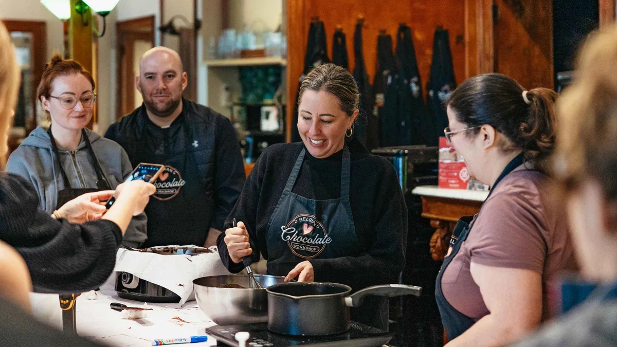 Participants making pralines at a Belgian chocolate making workshop, one of the chocolate tours in Brussels