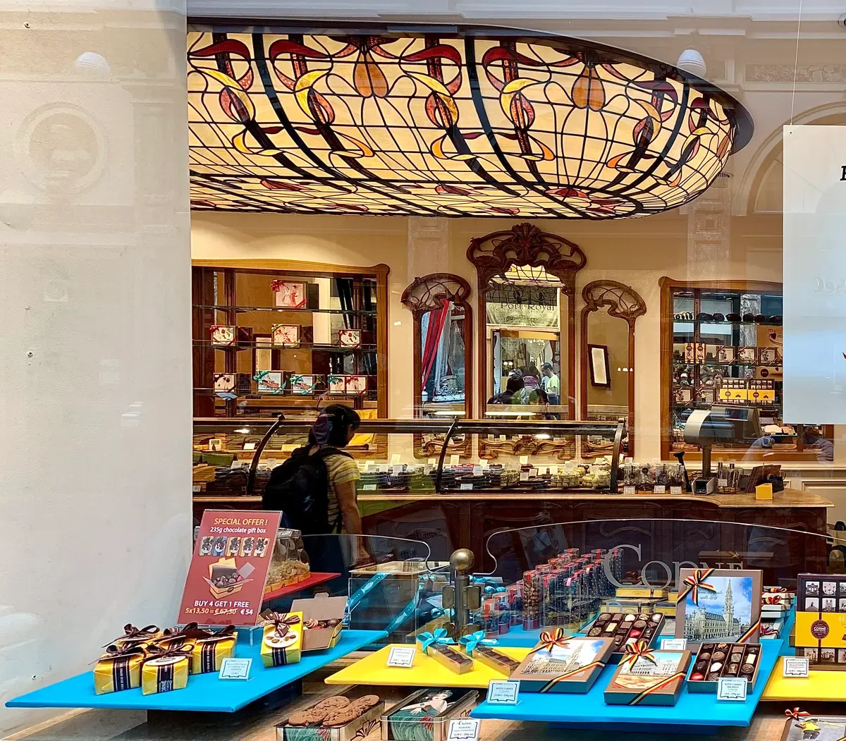 Chocolate shop interior seen through the window in the Galerie de la Reine, part of chocolate tours in Brussels